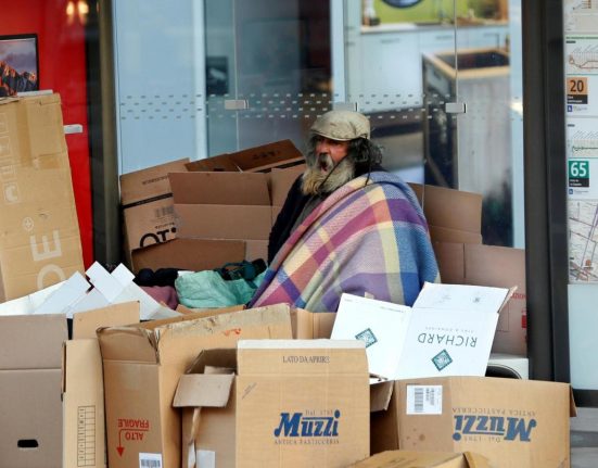 Un home en situació de carrer resguardat rere els cartrons a París | © Charles Platiau - Reuters
