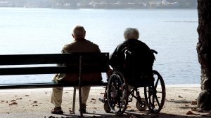 Una parella d'ancians asseguda, mirant el mar