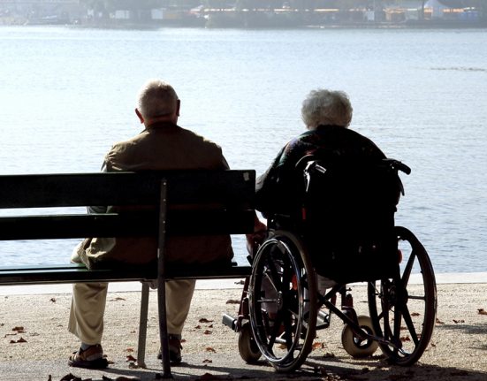 Una parella d'ancians asseguda, mirant el mar