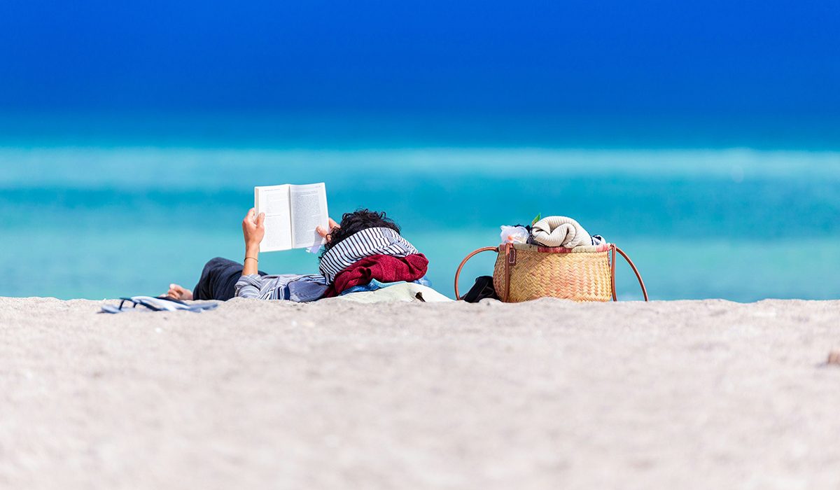 Una persona llegint a la platja | © Dan Dumitriu - Unsplash