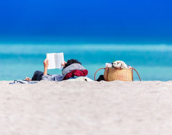 Una persona llegint a la platja | © Dan Dumitriu - Unsplash