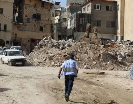 Un treballador de la UNRWA entre els enderrocs d'un bombardeig, a Gaza