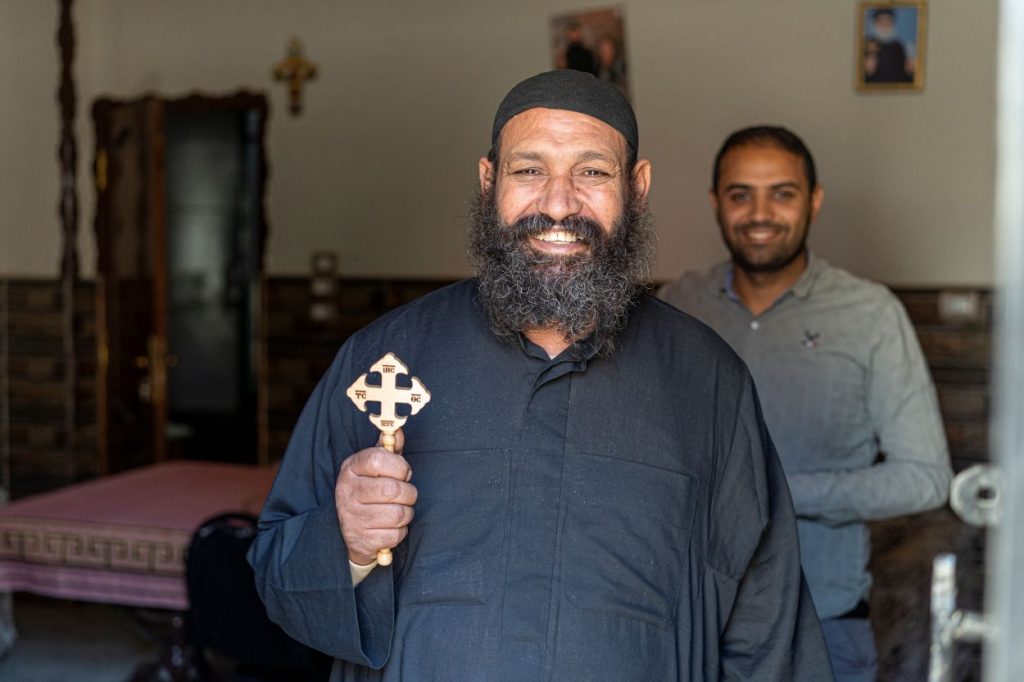 El sacerdot de Dayr Rifah, a la regió de Asiut, es mostra somrient a l'interior de casa seva