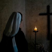 Una monja davant d’una creu | © Josh Applegate - Unsplash
